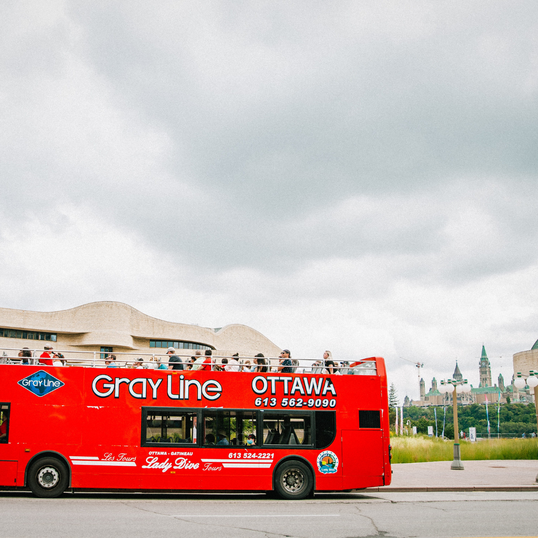 Ottawa Classic City Sightseeing Tour Gray Line red double-decker bus crossing bridge with passengers on a sunny day.1 Day Ottawa Bus and Canal Tour: Hop-on Hop Off & UNESCO Canal Cruise