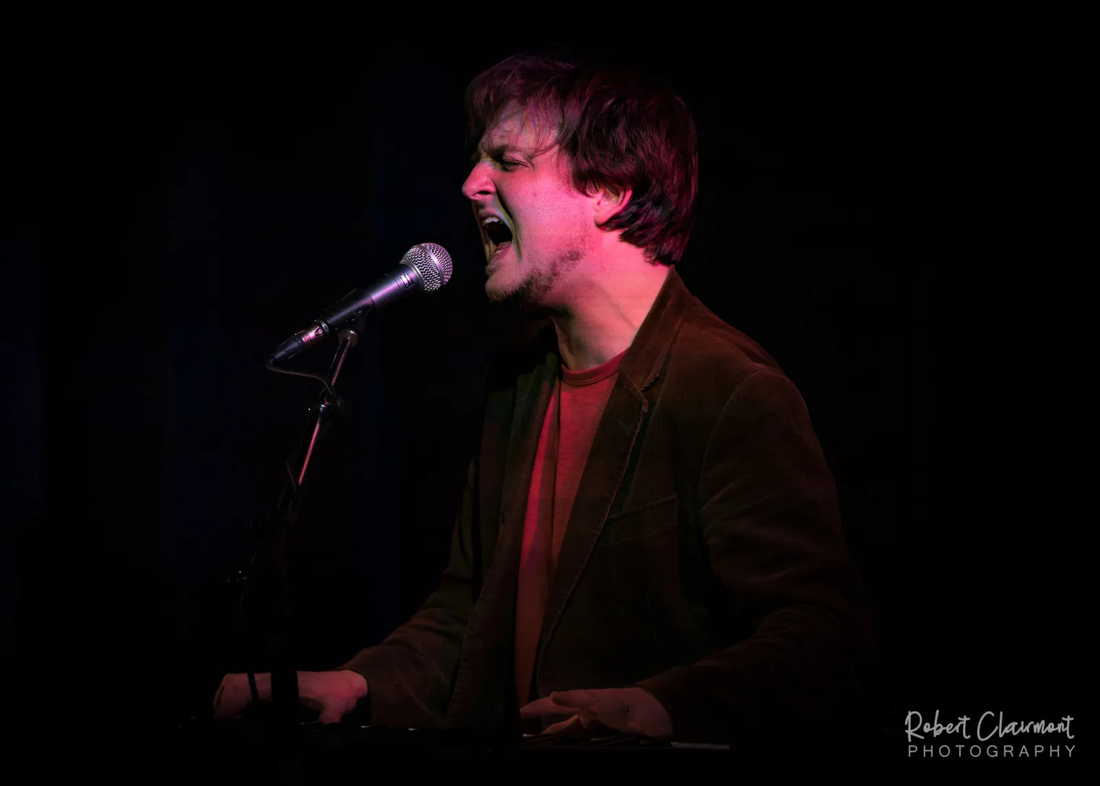 Dave Kalil performing passionately during the Dueling Pianos Cruise with intense vocal delivery.